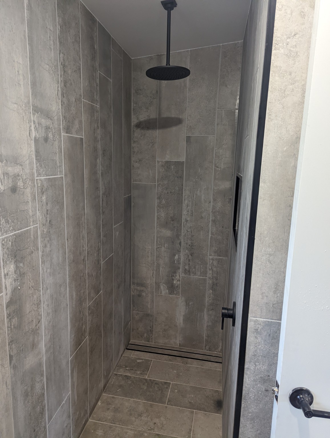 East Gosford granny flat — Tiled shower with black rainfall showerhead and linear drain